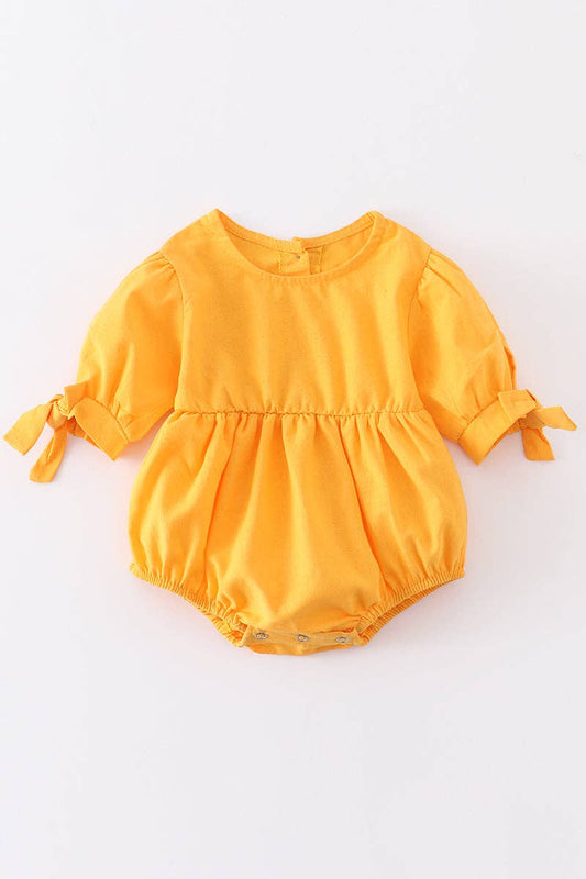 Mustard ruffle romper with bow on sleeve